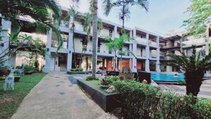 A multi-story hotel with a pool area, surrounded by greenery and palm trees. - Private 2 Bedrooms Villa Near Waterfall in Khao Lak-terrace Large Bubble Jacuzzi (Takua Pa)