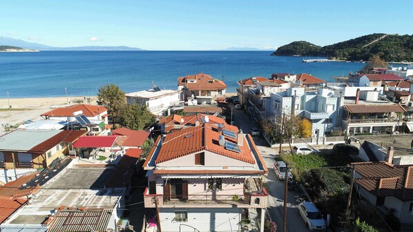 Un pueblo costero con edificios de tejas color terracota, una playa y una vista despejada del mar.