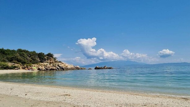 A beach with clear water, a rocky shoreline, and distant mountains. - Sunrise Suite Olympiada - Luxury Beachfront Escape (Aristotelis)