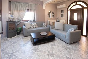 Una sala de estar con un sofá, una mesa de centro y un mueble para televisión.