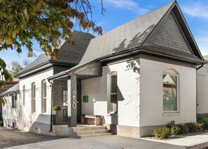 Ein zweistöckiges Gebäude mit weißer Fassade, grauem Dach und der Hausnummer 250.