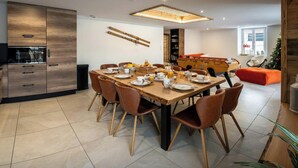 A modern dining area with a wooden table set for breakfast, surrounded by brown chairs. - La Ferme Geromoise - Gathering and exploring the Vosges - OVO Network (Gérardmer)