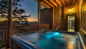 Ein Whirlpool auf einer Holzdiele mit einer Steinmauer und einer Holzbeschichtung.