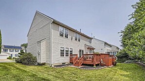 A two-story house with a front deck and a small porch. - Spacious Retreat in Prime Location — Comfort, Style & Convenience” (Owings Mills)