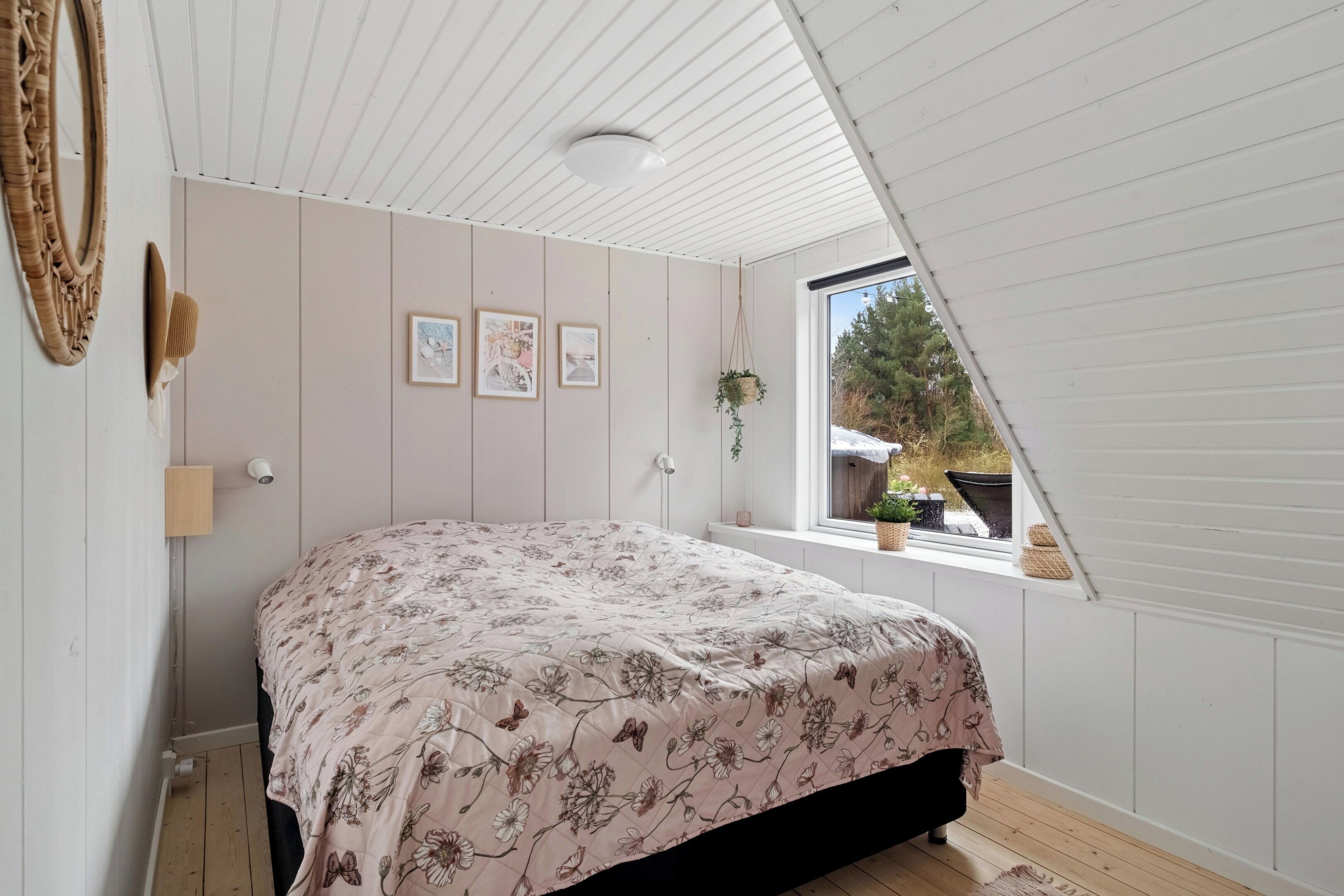 Um quarto com cama, janela e ventilador de teto.