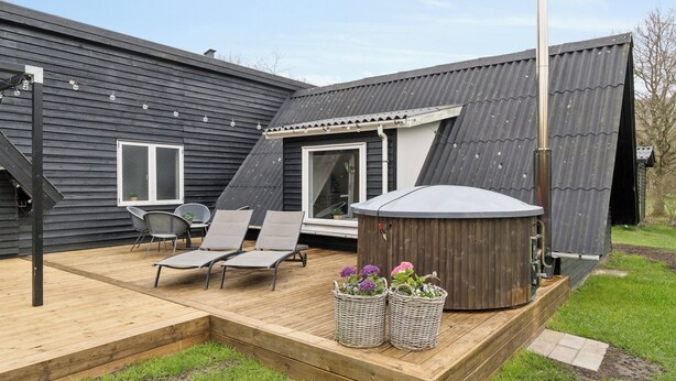 A deck with outdoor furniture, a hot tub, and a pergola structure. - Holiday home with spa, sauna and hot tub (Farsø)