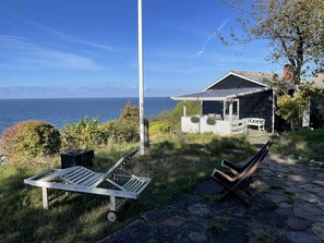 A coastal property with a patio area, a small deck, and a view of the sea. - Holiday home with stunning Baltic Sea view (Hasle)