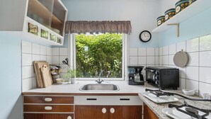 A kitchen with a window, a sink, a toaster, and a clock on the wall. - Holiday home with stunning Baltic Sea view (Hasle)