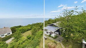 A coastal house with a solar panel roof, a flagpole, and a view of the sea. - Holiday home with stunning Baltic Sea view (Hasle)