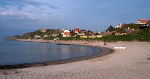 A coastal beach with houses, a boat on the sand, and a clear sky. - Idyllic wooden cabin with fireplace near Tisvilde (Frederiksværk)
