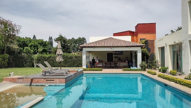 Ein Pool mit Sonnenterrasse und Liegestühlen.