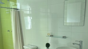 Ein modernes Badezimmer mit Toilette, Waschbecken und Dusche.