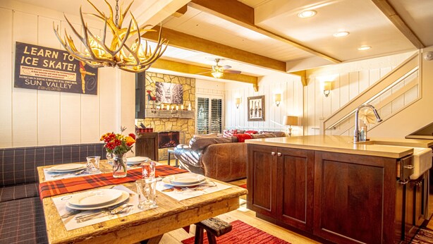 Eine moderne Küche mit einer Holzinsel, einem Essbereich mit kariertem Tischläufer und einem Schild an der Wand.