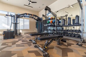 Ein Fitnessstudio mit Gewichthebern, Laufbändern und Kettlebells.