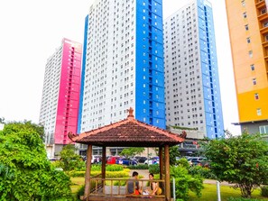 A gazebo in a park with a view of tall residential buildings in the background. - Trendy 2Br At Apartment Green Pramuka City (Jakarta)