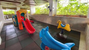 A children's play area with a slide, a climbing structure, and a rocking horse. - Strategic And Trendy Studio At Bassura City Apartment (Jakarta)