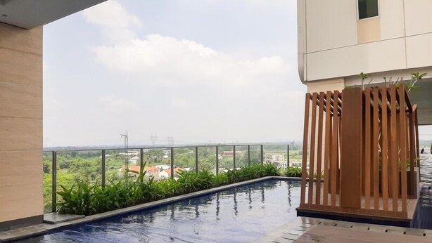 A rooftop pool with a view of the cityscape and greenery. - Relax Studio Room Apartment At B Residence (Pagedangan)