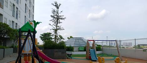 A playground with a slide, swings, and a climbing structure.