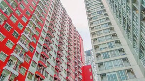 Un immeuble de grande hauteur doté de nombreux balcons et d’une façade rouge et blanche.
