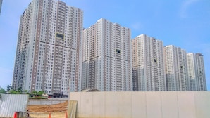 A high-rise residential building with multiple floors, large windows, and balconies. - Cozy And Simple Look Studio At Tokyo Riverside Pik 2 Apartment (Teluknaga)