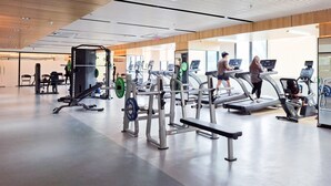 A gym with treadmills, weight machines, and a bench. - Elegant And Comfy 2Br Apartment Sky House Alam Sutera (Tangerang)