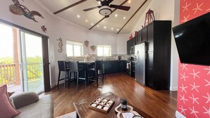 A modern kitchen with a dining area, a ceiling fan, and a large window. - Layin Low...Two Villas Offering 4 bedrooms, 2.5 baths on beautiful Staniel Cay (Staniel Cay)