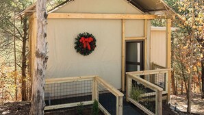 Une petite cabane en bois avec un porche, une porte et une guirlande accrochée au mur.