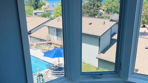 Una habitación con un amplio ventanal que da a una piscina y vistas despejadas al mar.