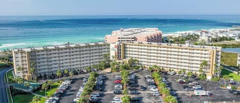 A large hotel with multiple floors and a parking lot.