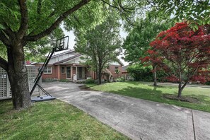 A residential driveway leading to a brick house with a basketball hoop. - Coorabin | Pet-Friendly 4BR near Orange CBD (Orange)