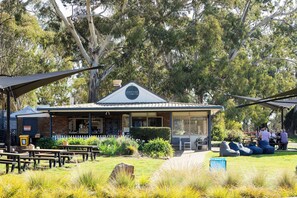 A restaurant with outdoor seating, a signboard, and a garden area. - Coorabin | Pet-Friendly 4BR near Orange CBD (Orange)
