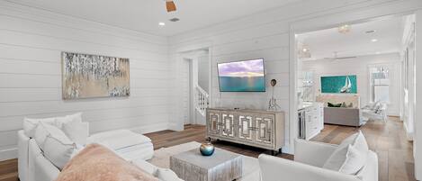 Un salón amplio con un sofá blanco, una mesa de centro y un televisor.