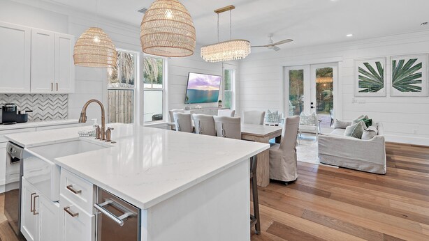 A modern kitchen with white cabinetry, a large island, and pendant lighting. - 6BR 30A Oasis • Pool, Golf Cart & Bikes (Seagrove Beach)