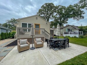 A house with a deck, outdoor furniture, and a staircase. - The Salt Box Beach House. 2 Blocks to Beach. (Villas)