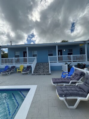 A blue building with a pool, outdoor seating, and a stone staircase. - Brand New One Bedroom Apartment 
George Town Exuma/with Private Pool (George Town)