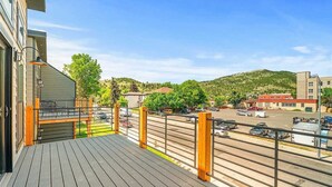 Ein Balkon mit Blick auf einen Parkplatz und Gebäude im Hintergrund.