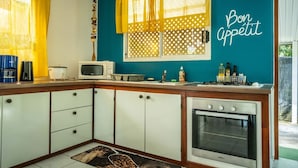Una cocina con microondas, estufa y alacenas.