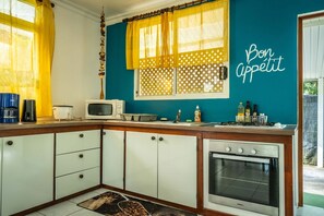 Una cocina equipada con microondas, estufa y armarios.