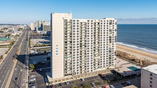 A high-rise hotel with multiple floors, a parking lot, and a view of the beach and ocean. - 9400 Building #401 (Ocean City)
