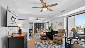 A modern living room with a sofa, chairs, a dining area, and a ceiling fan. - 9400 Building #401 (Ocean City)
