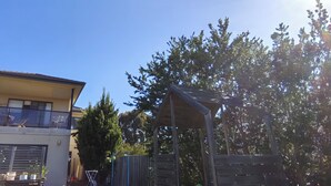 A modern two-story house with a balcony, a wooden deck, and a fenced garden area. - 3B parkview Sancatury Lake house for 6people &Wifi&Lake&golf&SPA (Point Cook)