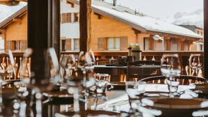 Ein Restaurant mit Holzbalken und Blick auf schneebedeckte Häuser.