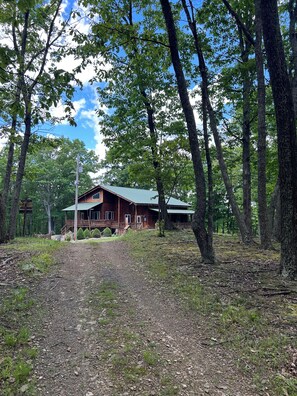 A rustic cabin with a porch, surrounded by trees and a gravel path. - Secluded Woodland Lodge [Sleeps 10] Walking Trails + Fire Pit (Everett)