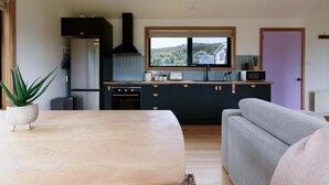 Una cocina moderna con armarios oscuros, un ventanal y vistas al exterior.