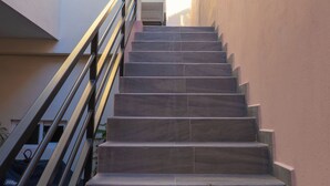 Un escalier avec une rampe métallique menant à un niveau supérieur.