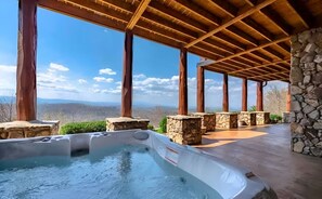 A hot tub under a wooden pergola with stone pillars, overlooking a mountainous landscape. - Luxury Lodge: Heated Pool, Spa, Mountain Views, Sleeps 16 (blue ridge)