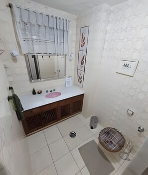 A bathroom with a wooden vanity, a mirror, a towel rack, and a shower area. - 3 Minutos da Praia - Prime Location (Rio de Janeiro)