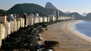 A coastal cityscape with high-rise buildings, a beach, and a prominent mountain in the background. - 3 Minutos da Praia - Prime Location (Rio de Janeiro)