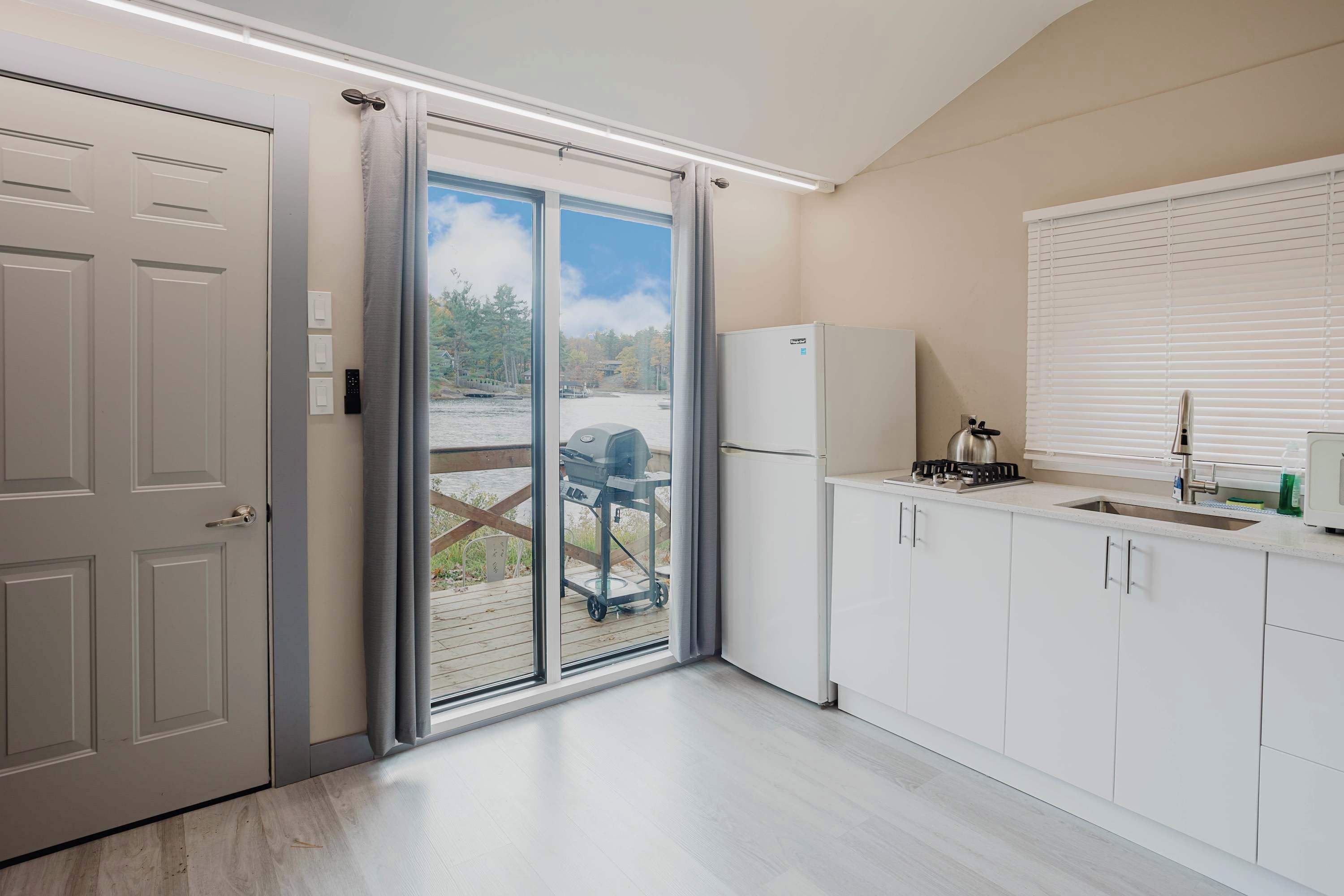 Een koelkast, een magnetron, een kookplaat, kookgerei, borden en bestek