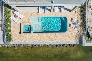 Ein Luftbild eines Poolbereichs mit Liegestühlen und einem kleinen Pool.